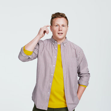 Man touching temple, wearing yellow shirt